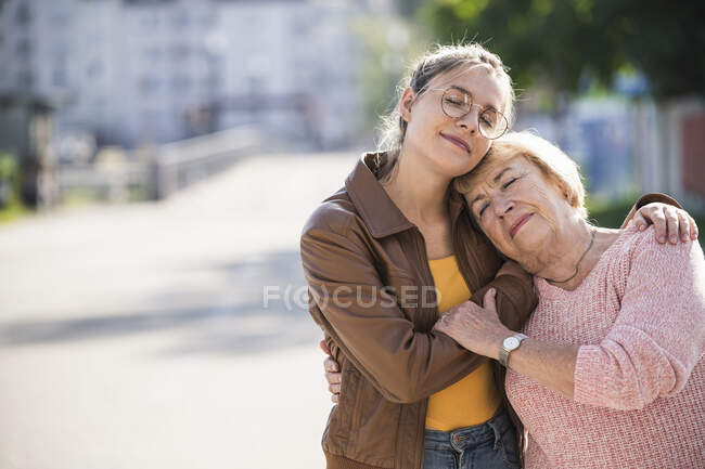 Внучка обнимает бабушку — стоковое фото