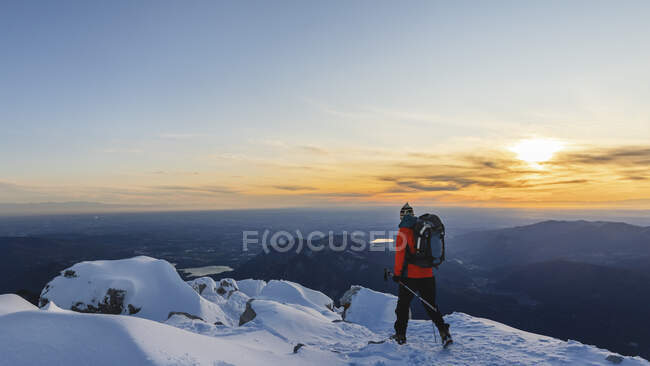 Mountaineer walking on top of a snowy mountain, Lecco, Italia - foto de stock