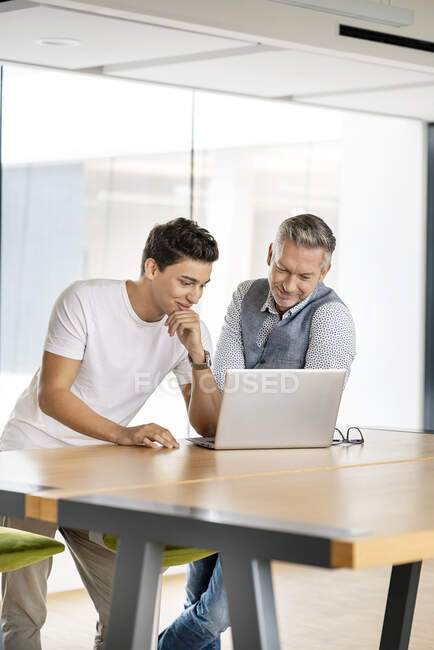 Senior businessman working with young colleague, using laptop — Stock Photo