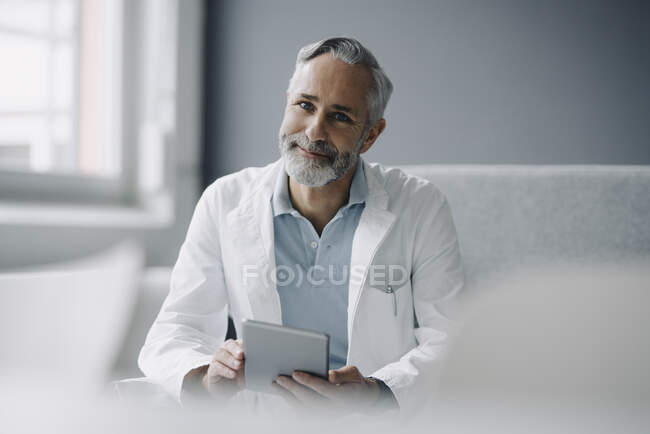 Retrato del médico sonriente con tableta digital - foto de stock