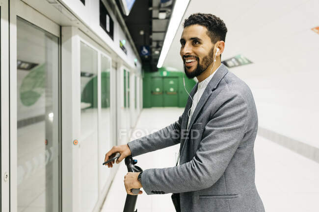 Jovem empresário com scooter elétrico na estação de metrô — Fotografia de Stock