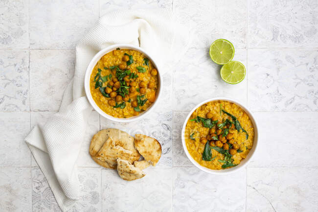 Curry vegano di lenticchie con lenticchie rosse, patate dolci, spinaci, curcuma arrosto, ceci, con succo di lime e coriandolo e pane naan — Foto stock