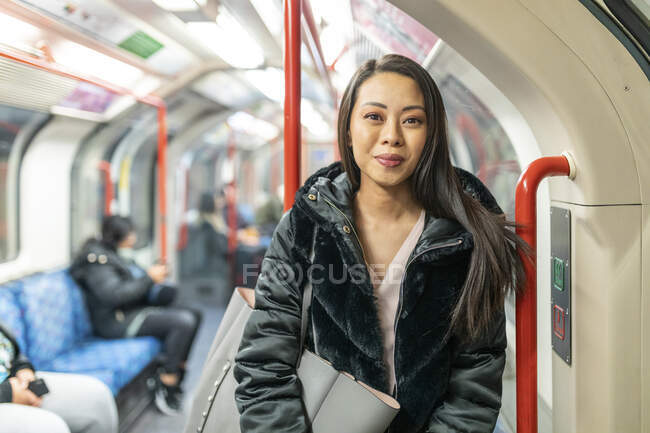 Retrato de la mujer de contenido en tren subterráneo, Londres, Reino Unido - foto de stock