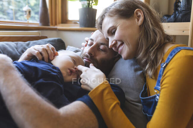 Affectionate family on the sofa with sleeping little son — Stock Photo
