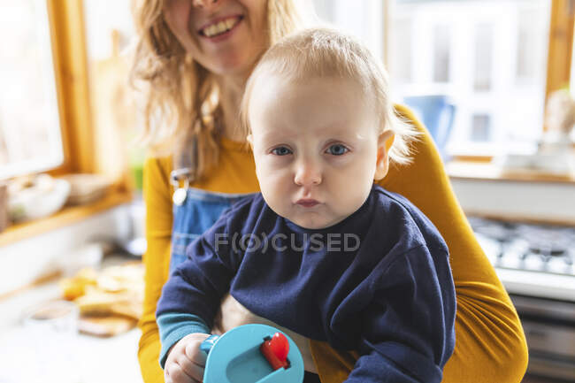 Портрет хлопчика, який тримає його мати робить смішне обличчя — стокове фото