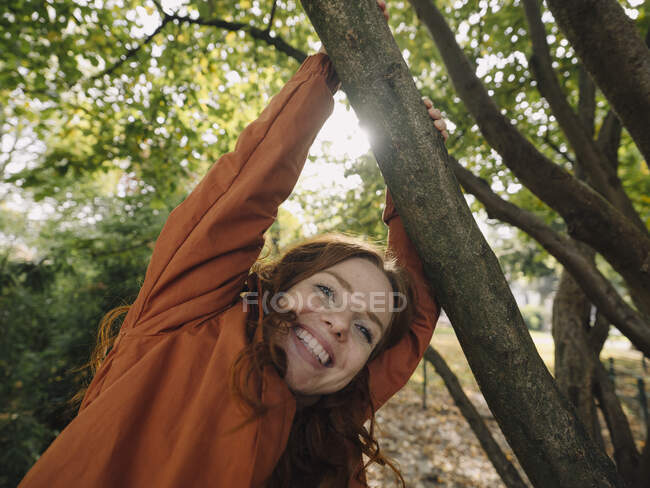 Mujer pelirroja feliz disfrutando del otoño en un parque - foto de stock