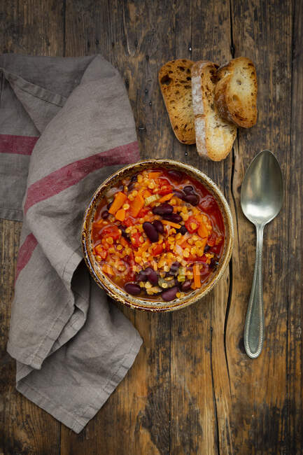 Bowl of vegan chili with red lentils, celery sticks, kidney beans, tomatoes and carrots — Stock Photo