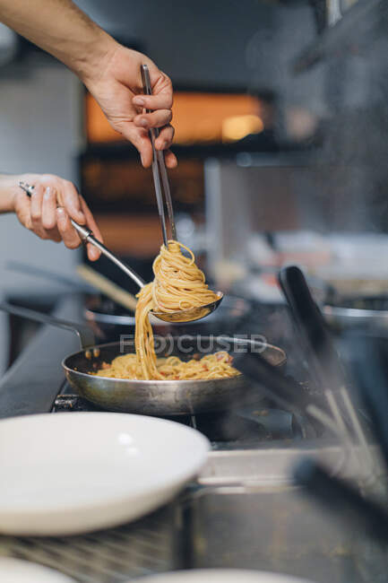 Chef prepara un piatto di pasta nella cucina tradizionale italiana del  ristorante — Delizioso, primo piano - Stock Photo | #470143262
