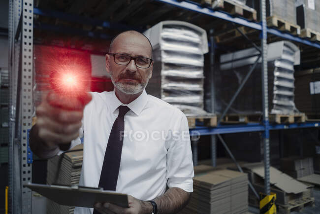 Retrato del hombre con escáner brillante en almacén de fábrica - foto de stock