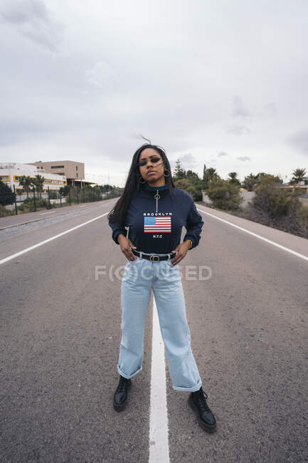 Portrait of cool young woman standing on a road — Stock Photo