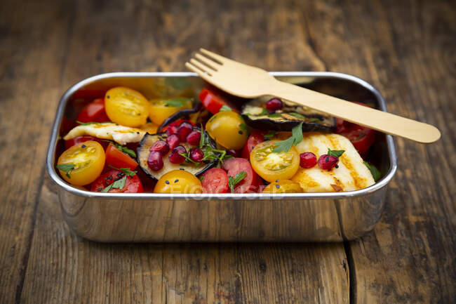 Lunch box with tomato salad with grilled vegetables andhalloumicheese, pomegranate seeds, sumac, black sesame and parsley — Stock Photo