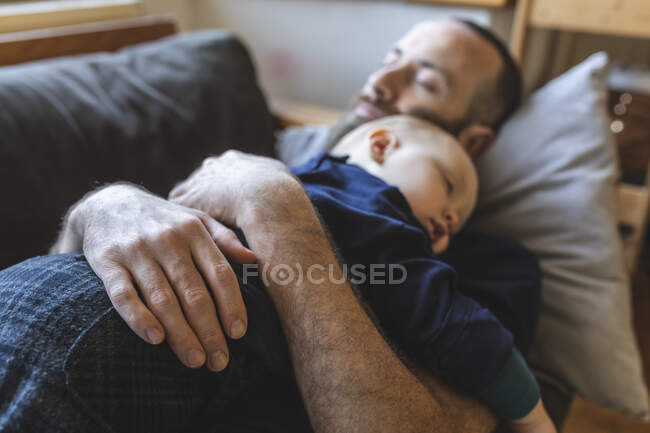 Father and son sleeping together on the sofa — Stock Photo