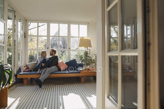 Ласковая пара отдыхает в солнечной комнате дома — стоковое фото