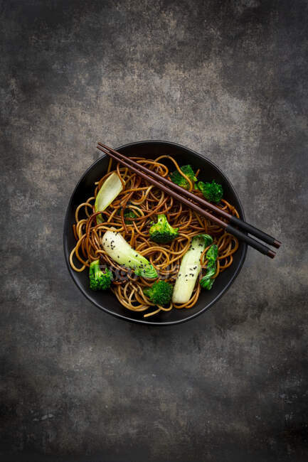Vista aerea di ciotola di spaghetti di soba con pak choi e broccoli, salsa di soia e sesamo nero — Foto stock