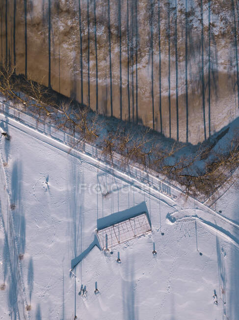 Russland, Oblast Leningrad, Tichwin, Luftaufnahme einer schneebedeckten Straße, die sich entlang eines gefrorenen Teiches erstreckt — Stockfoto