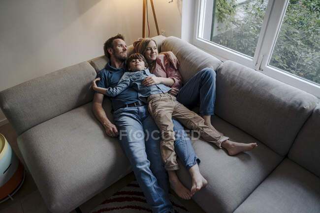 Счастливая семья отдыхает на диване — стоковое фото