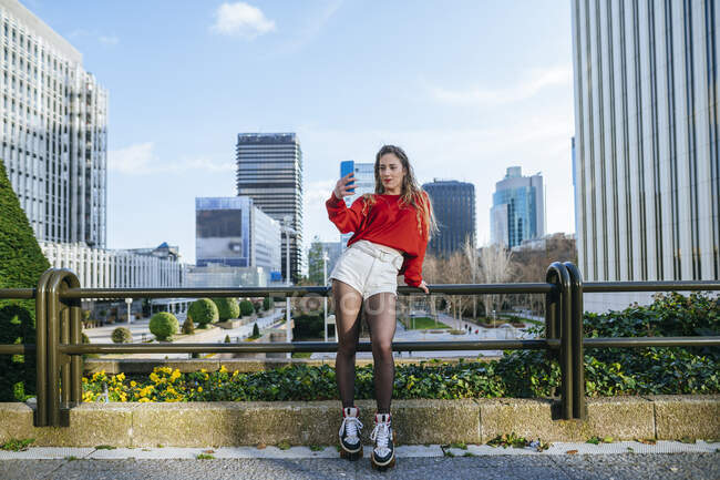 Молода жінка на роликових ковзанах бере селфі в місті — стокове фото