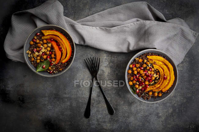 Red quinoa with baked pumpkin, chickpeas, pomegranate, basil, walnuts and pumpkin seeds — Stock Photo