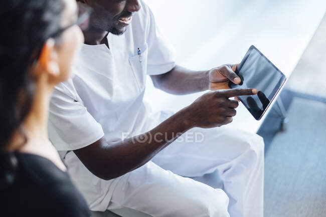 Dentist with tablet speaking with female patient in dental surgery — Stock Photo