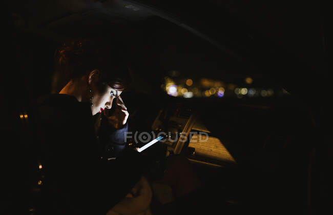 Mujer joven usando smartphone por la noche - foto de stock