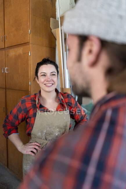 Craftswoman and craftsman talking in their workshop — Stock Photo