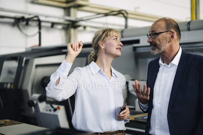 Бізнесмен і жінка розмовляють на фабриці. — стокове фото