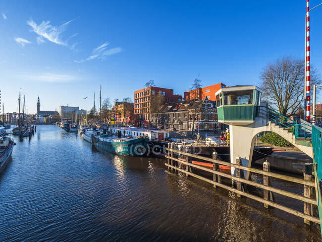 Niederlande, Friesland, Groningen, Jachthaven Oosterhaven, Stadt und Boote am Kanal festgemacht — Stockfoto