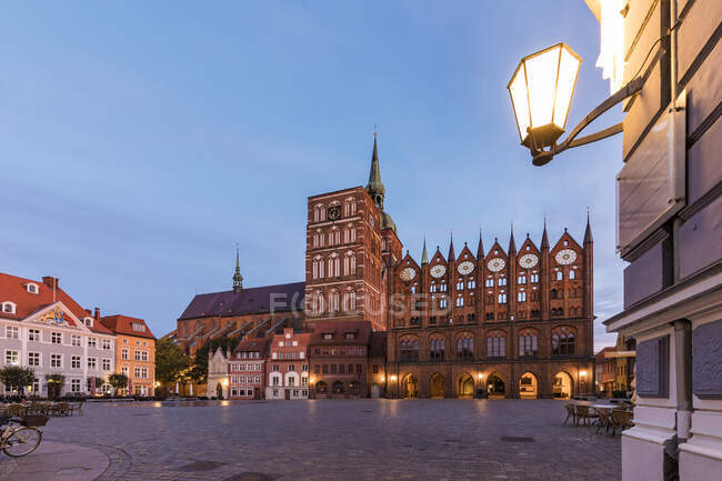 Alemania, Mecklemburgo-Pomerania Occidental, Stralsund, Plaza de la ciudad frente a la iglesia de San Nicolás al atardecer - foto de stock