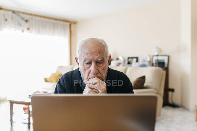 Ritratto di uomo anziano che usa il computer portatile a casa — Foto stock