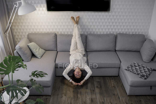 Mujer relajándose boca abajo en el sofá - foto de stock