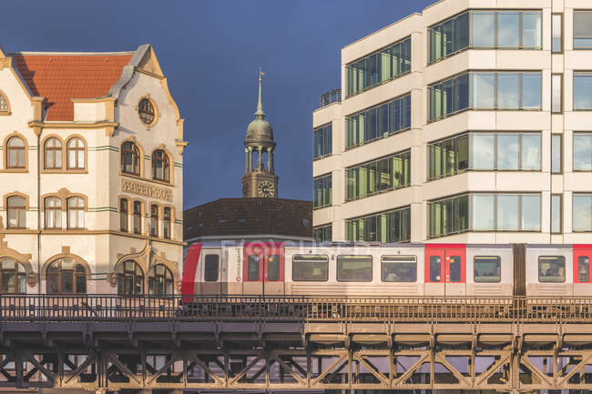 Германия, Гамбург, Высокий поезд с башней церкви Святого Михаила на заднем плане — стоковое фото