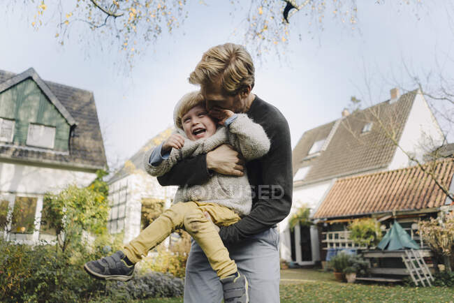 Buon padre che gioca con il figlio in giardino — Foto stock