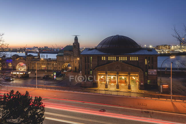 Alemanha, Hamburgo, Trilhas ligeiras para veículos em frente à estação ferroviária de Landungsbrucken ao entardecer — Fotografia de Stock