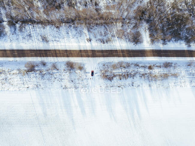 Russia, Moscow Oblast, Aerial view of car driving into snow-covered field — Stock Photo