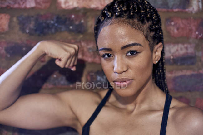Atleta feminina que flexiona bíceps, retrato — Fotografia de Stock