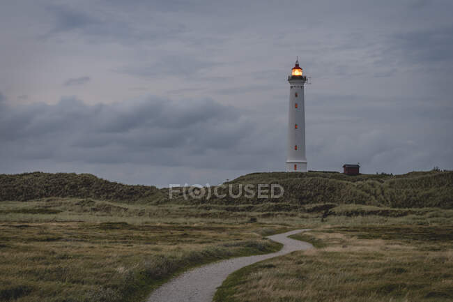 Danimarca, Hvide Sande, sentiero verso il faro costiero al crepuscolo — Foto stock