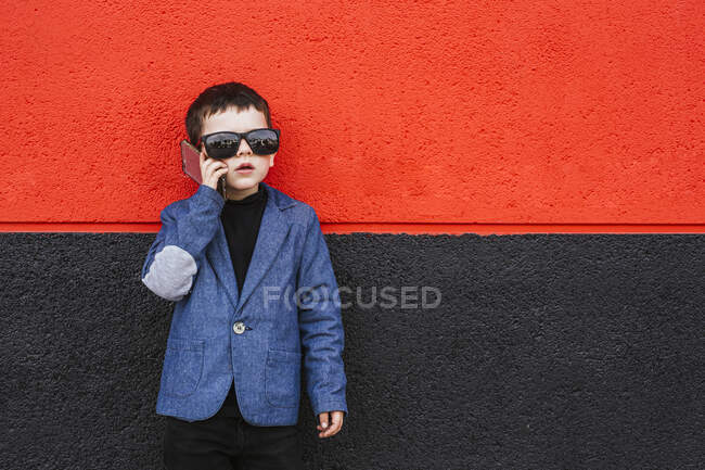 Портрет мальчика на телефоне в костюме и огромных солнцезащитных очках — стоковое фото