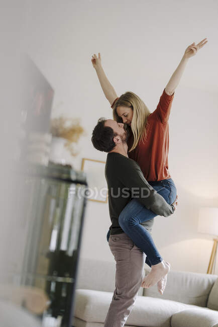 Man lifting and embracing his cheering wife — Stock Photo