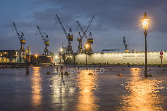 Deutschland, Hamburg, Altonaer Fischmarkt während der Flut mit Hafenkränen im Hintergrund — Stockfoto