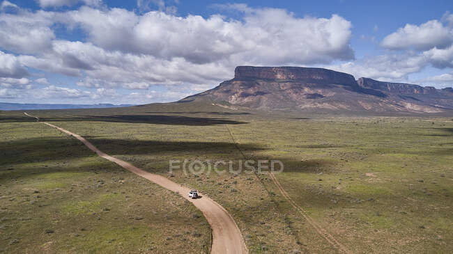 Afrique du Sud, Cap Occidental, Blanco, Vue aérienne du 4x4 blanc conduisant sur un chemin de terre vers les montagnes — Photo de stock