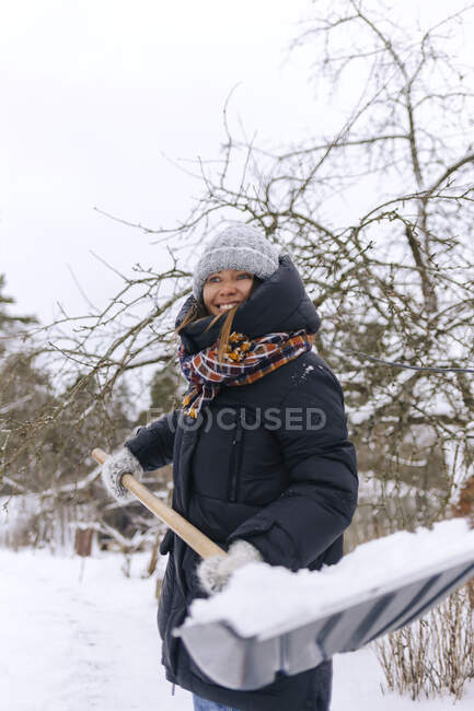Ritratto di donna sorridente con pala da neve — Foto stock