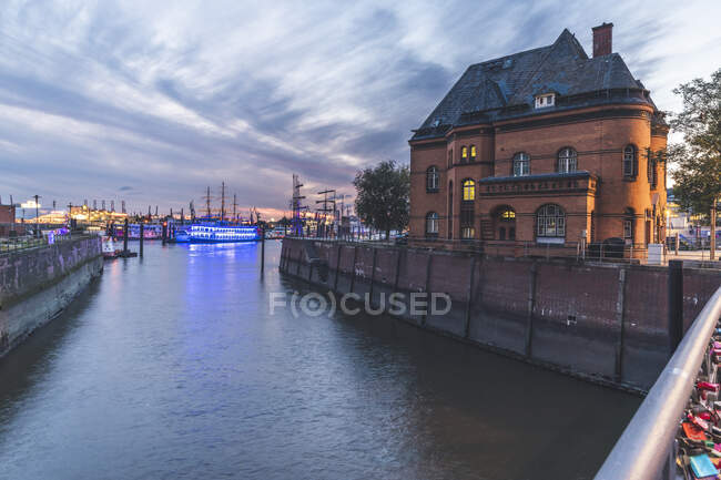 Germania, Amburgo, Stazione di polizia ai margini del canale del fiume Elba con il porto sullo sfondo — Foto stock
