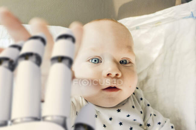 Портрет мальчика, который тянется к руке робота — стоковое фото