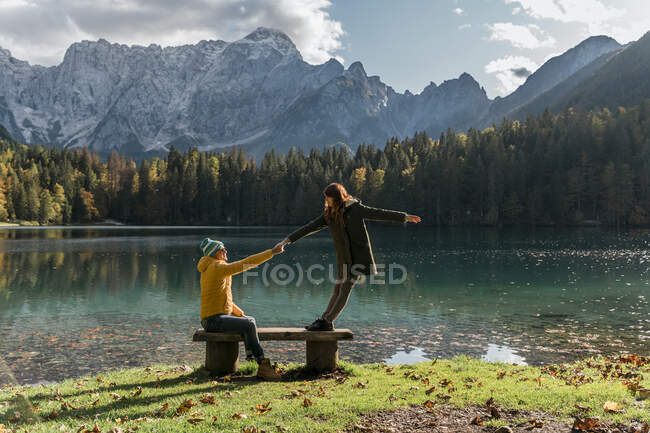 Couple holding hand on a bench at Laghi di Fusine, Friuli Venezia Giulia, Italy — Stock Photo