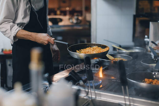 Chef cooking pasta in Italian restaurant kitchen — Stock Photo