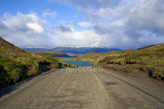 Chile, Província de Ultima Esperanza, Nuvens sobre estrada de terra vazia no Parque Nacional Torres del Paine — Fotografia de Stock