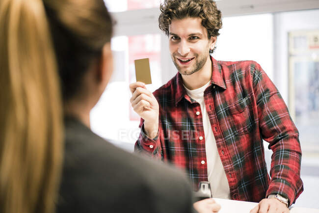 Man paying with credit card at the counter of a shop — Stock Photo