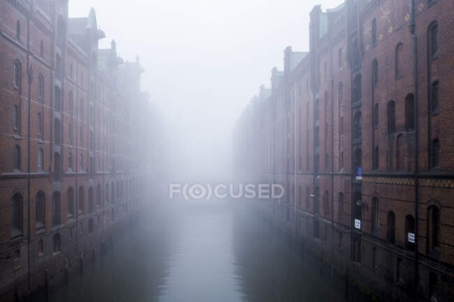 Німеччина, Гамбург, Шпіхерштадт, Старі склади і канал в тумані — стокове фото