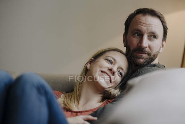 Пара сидящая дома на диване, расслабляющая — стоковое фото