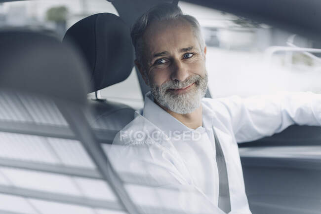 Portrait of smiling mature businessman in his car — Stock Photo